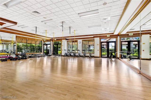 exercise room featuring french doors, light wood-type flooring, and crown molding