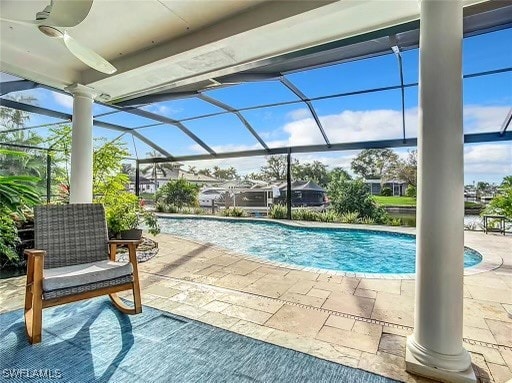 view of pool with ceiling fan, glass enclosure, and a patio area