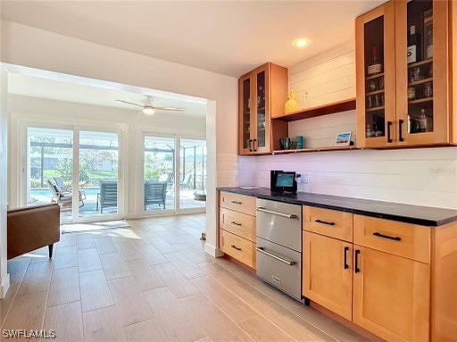 kitchen with light brown cabinetry, ceiling fan, and tasteful backsplash