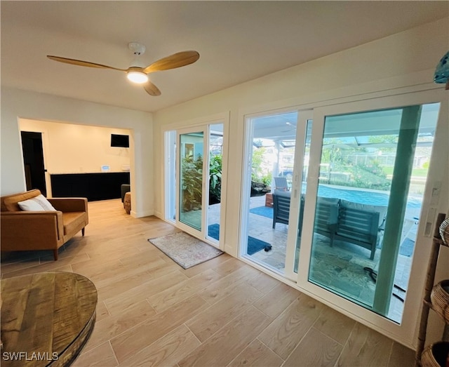 doorway to outside with ceiling fan and light hardwood / wood-style flooring