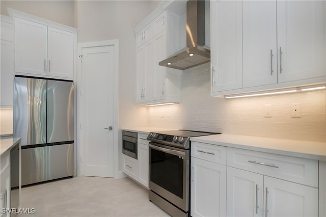 kitchen with backsplash, appliances with stainless steel finishes, wall chimney exhaust hood, and white cabinets