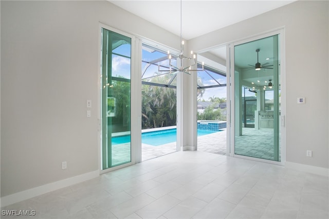 interior space with light tile patterned floors and ceiling fan with notable chandelier