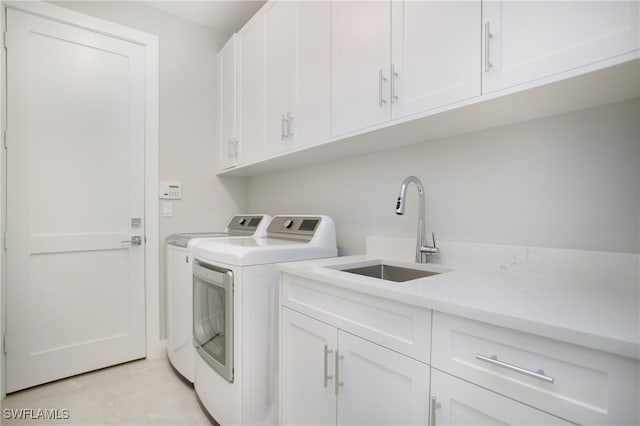 laundry area with washer and clothes dryer, cabinets, and sink