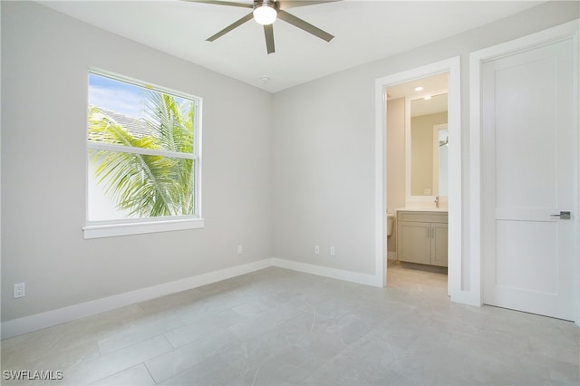 unfurnished bedroom featuring ensuite bath and ceiling fan