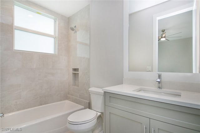 full bathroom with tiled shower / bath, ceiling fan, toilet, and vanity