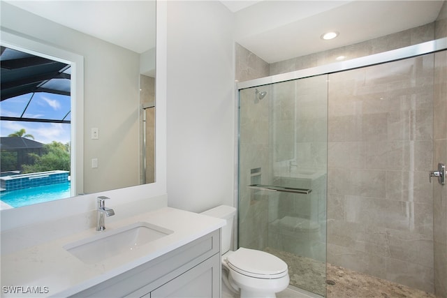 bathroom with walk in shower, vanity, and toilet