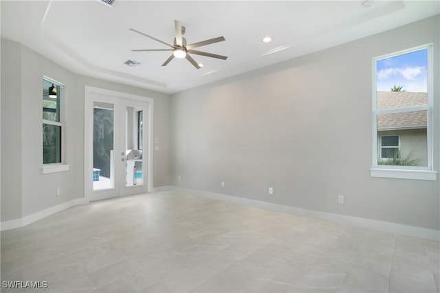 unfurnished room with french doors, ceiling fan, and a raised ceiling