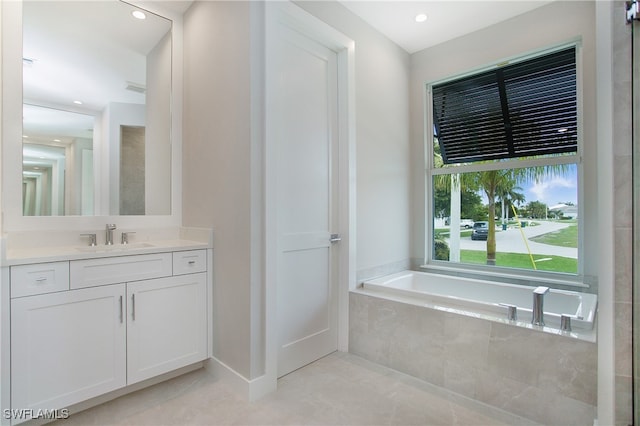 bathroom with tiled bath and vanity