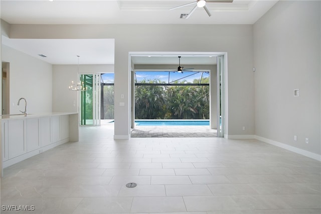 spare room with sink, ceiling fan with notable chandelier, light tile patterned floors, and plenty of natural light