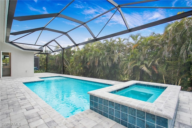 view of pool with a patio, a lanai, and an in ground hot tub