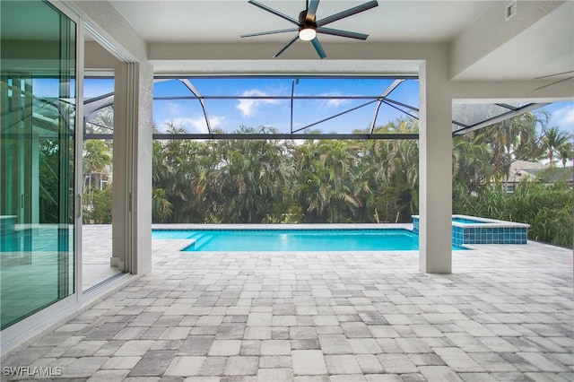 view of pool with ceiling fan, a lanai, an in ground hot tub, and a patio area