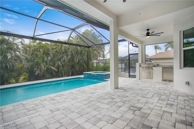 view of pool with a lanai, an in ground hot tub, exterior kitchen, and a patio area