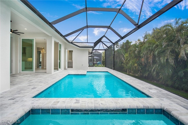 view of swimming pool with ceiling fan, a lanai, and a patio area