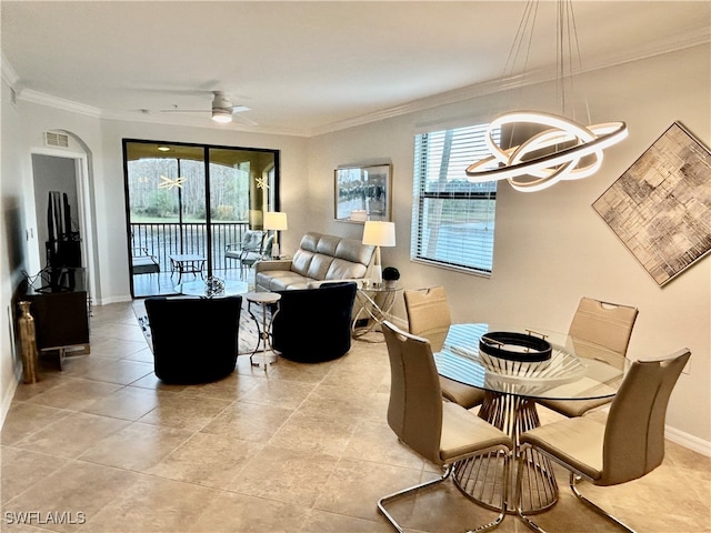 tiled dining space featuring ceiling fan with notable chandelier, a healthy amount of sunlight, and crown molding