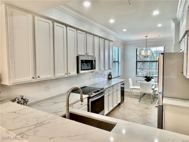 kitchen with ornamental molding, appliances with stainless steel finishes, decorative light fixtures, decorative backsplash, and sink