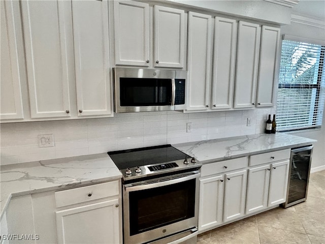 kitchen with stainless steel appliances, white cabinetry, light tile patterned floors, light stone countertops, and beverage cooler