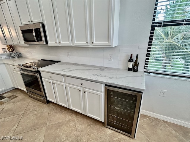 kitchen with stainless steel appliances, a wealth of natural light, wine cooler, and decorative backsplash