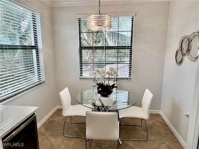 dining space with a chandelier, light tile patterned flooring, and crown molding