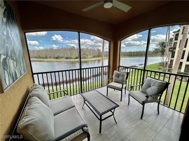 sunroom with a water view and ceiling fan