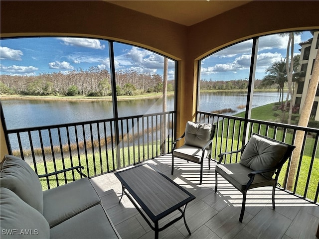 sunroom featuring a water view