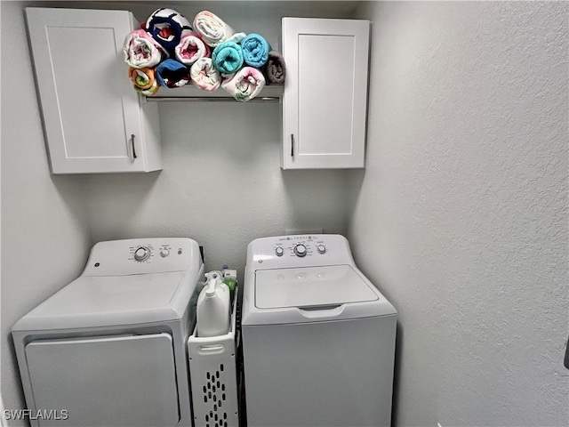 washroom with cabinets and washing machine and clothes dryer