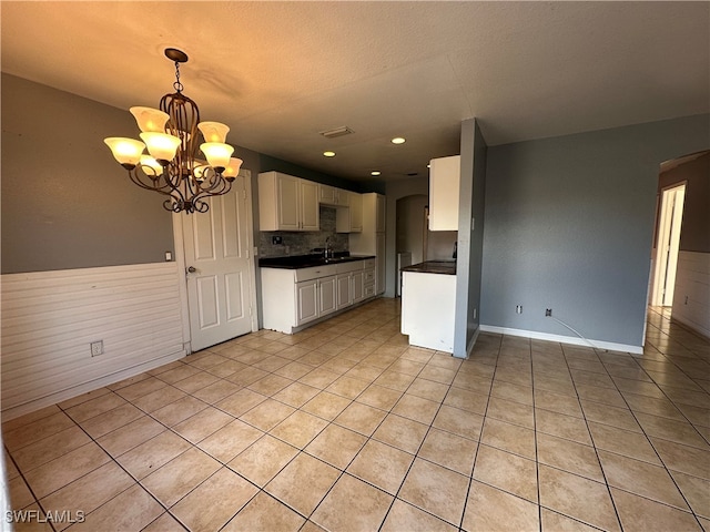 kitchen with white cabinetry, decorative light fixtures, light tile patterned floors, sink, and a chandelier