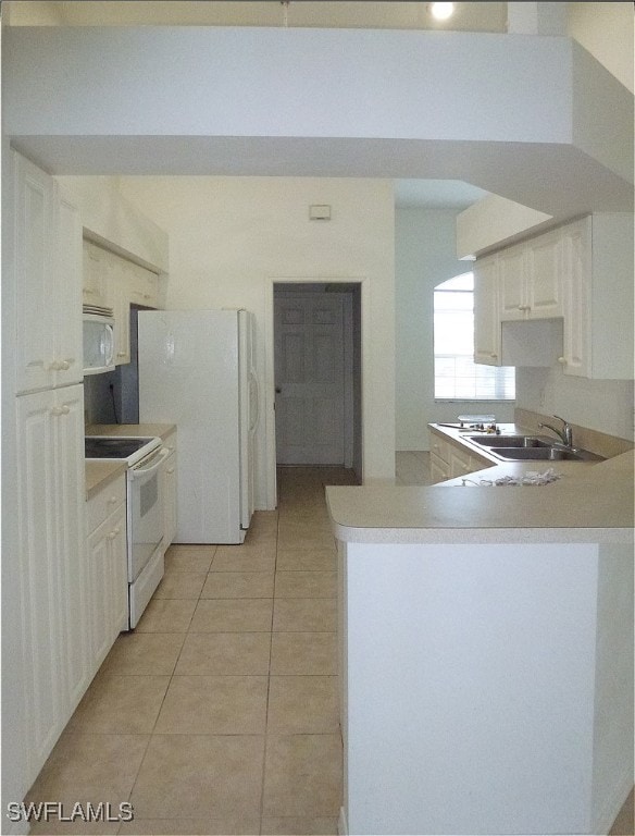 kitchen featuring white cabinetry, white appliances, light tile patterned floors, sink, and kitchen peninsula