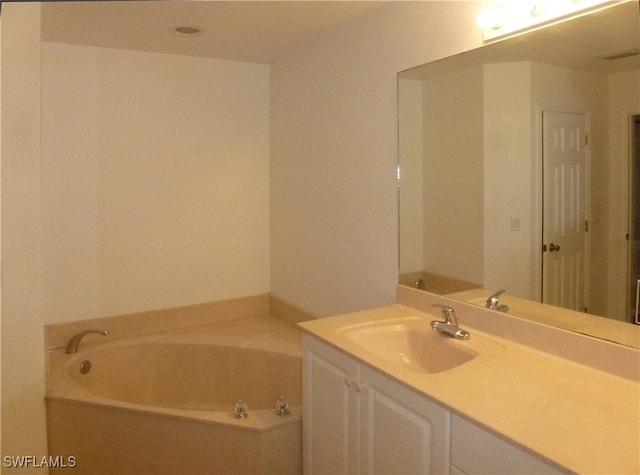 bathroom with a tub and vanity