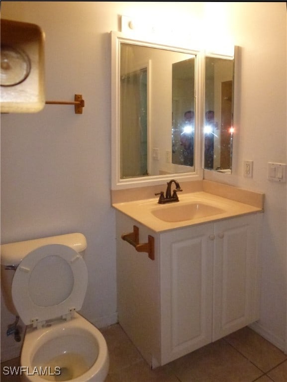 bathroom featuring vanity, tile patterned floors, and toilet