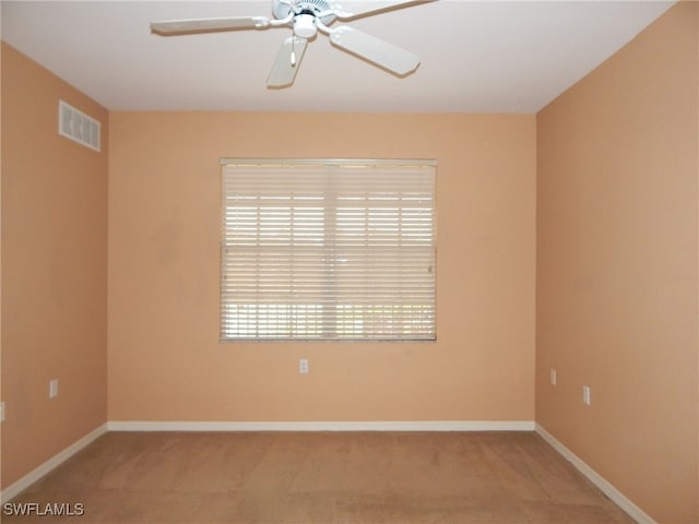 carpeted spare room featuring ceiling fan