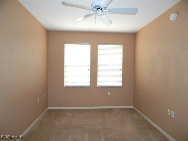 carpeted spare room featuring ceiling fan