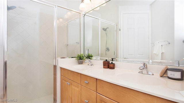 bathroom with a shower with shower door and vanity