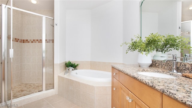 bathroom featuring shower with separate bathtub, tile patterned floors, and vanity