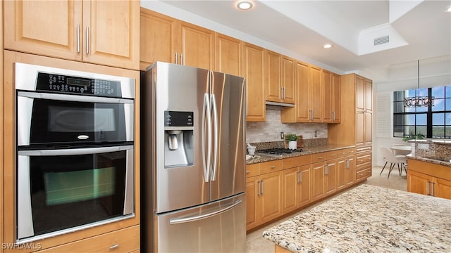 kitchen featuring stainless steel appliances, light tile patterned floors, a chandelier, tasteful backsplash, and light stone countertops