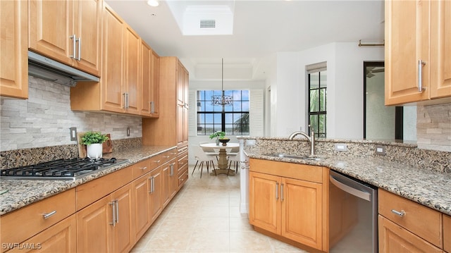 kitchen with stainless steel appliances, backsplash, and light stone countertops