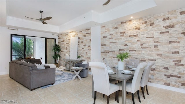 dining area featuring ceiling fan, ornamental molding, light tile patterned floors, and a tray ceiling