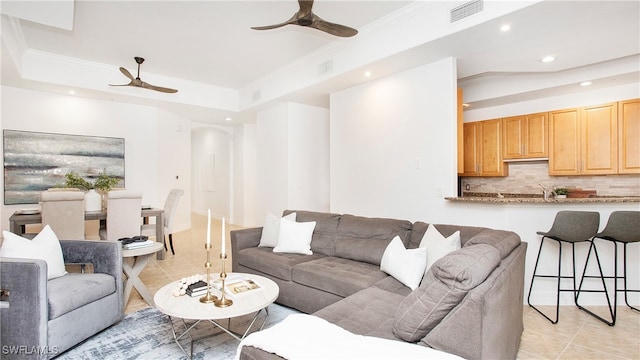 living room featuring crown molding, light tile patterned floors, ceiling fan, and a tray ceiling