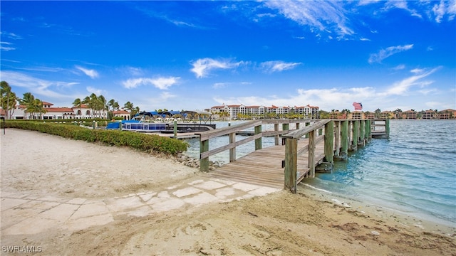 view of dock featuring a view of the beach and a water view