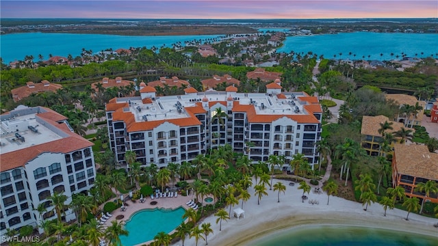 aerial view at dusk featuring a water view