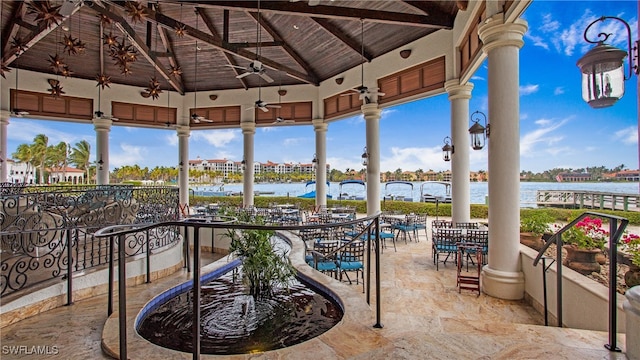 exterior space with lofted ceiling with beams, a water view, wood ceiling, and ceiling fan