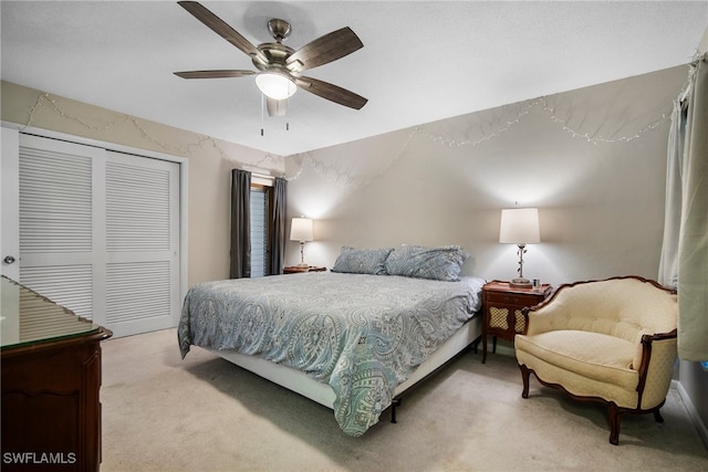 bedroom featuring a closet, light colored carpet, and ceiling fan