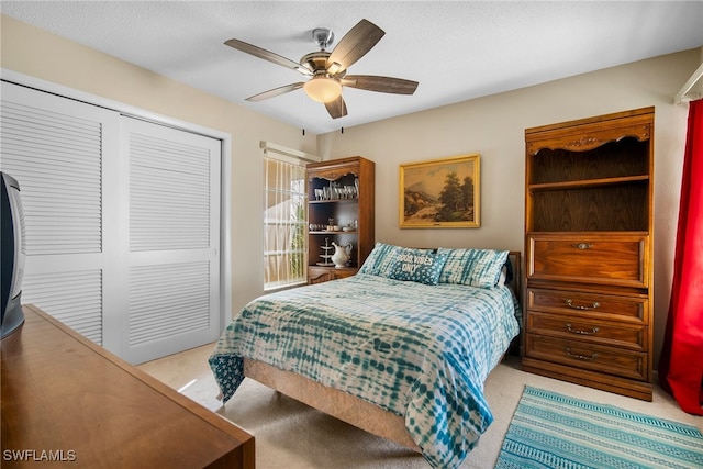 bedroom featuring a closet, light carpet, and ceiling fan