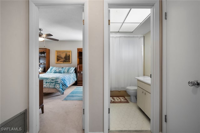 interior space with ceiling fan and connected bathroom