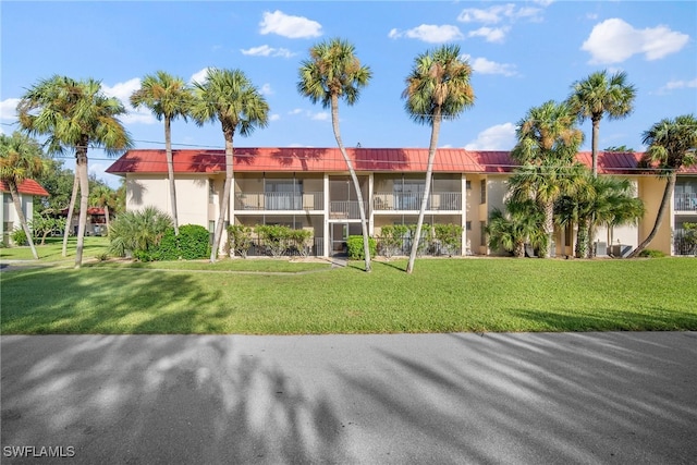 view of front of home featuring a balcony and a front yard