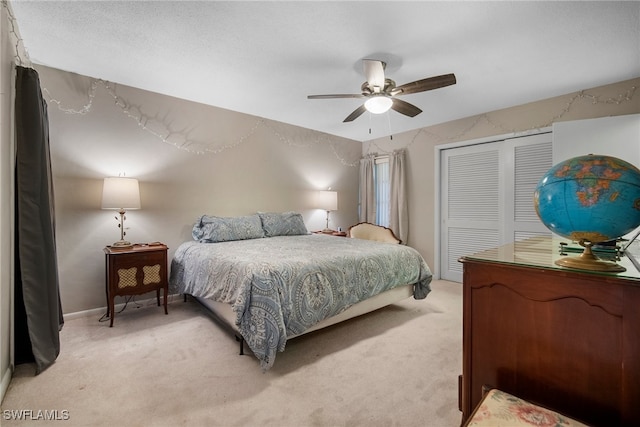 bedroom with light carpet, ceiling fan, and a closet