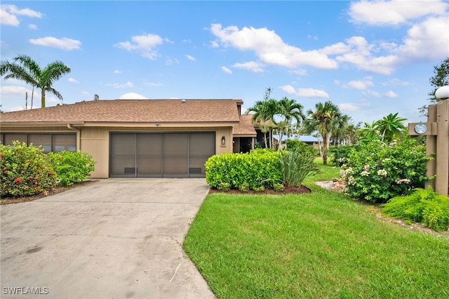 ranch-style house with a garage and a front lawn