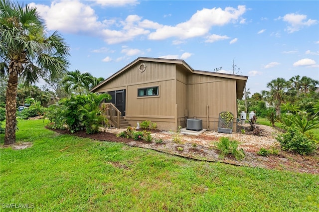 view of home's exterior with a yard and central AC unit