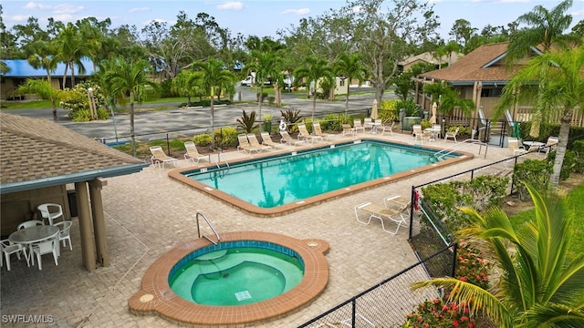 view of pool featuring a community hot tub and a patio