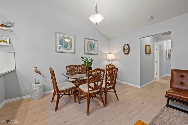 dining room featuring light wood-type flooring and lofted ceiling