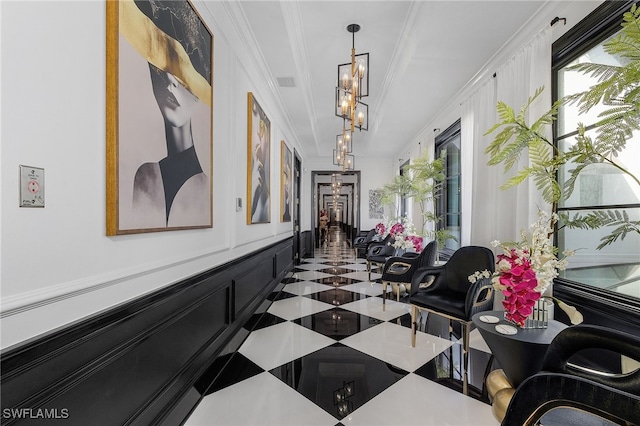 hall featuring crown molding and an inviting chandelier